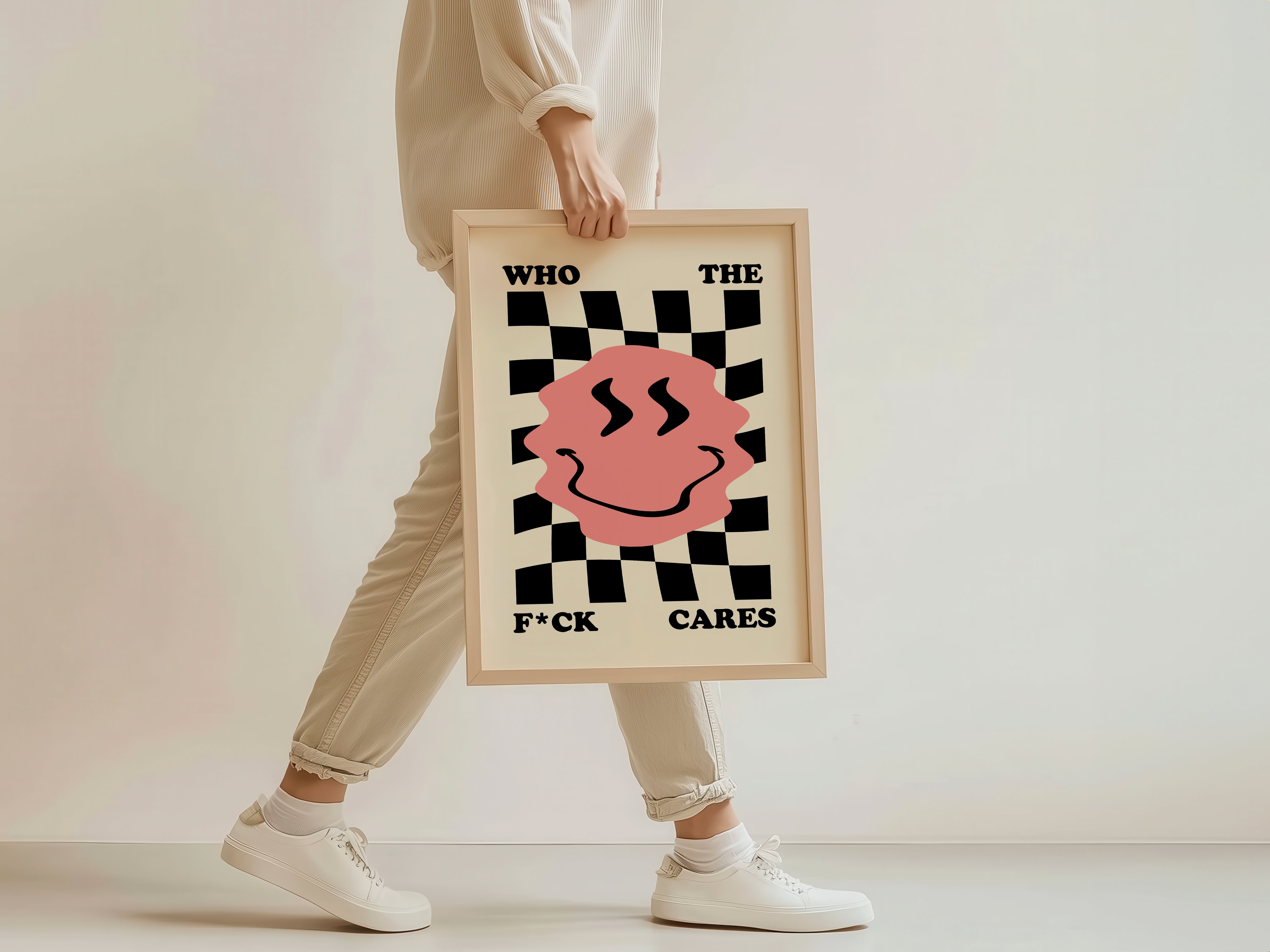 Person holding a framed poster with a checkered design and text on a plain background